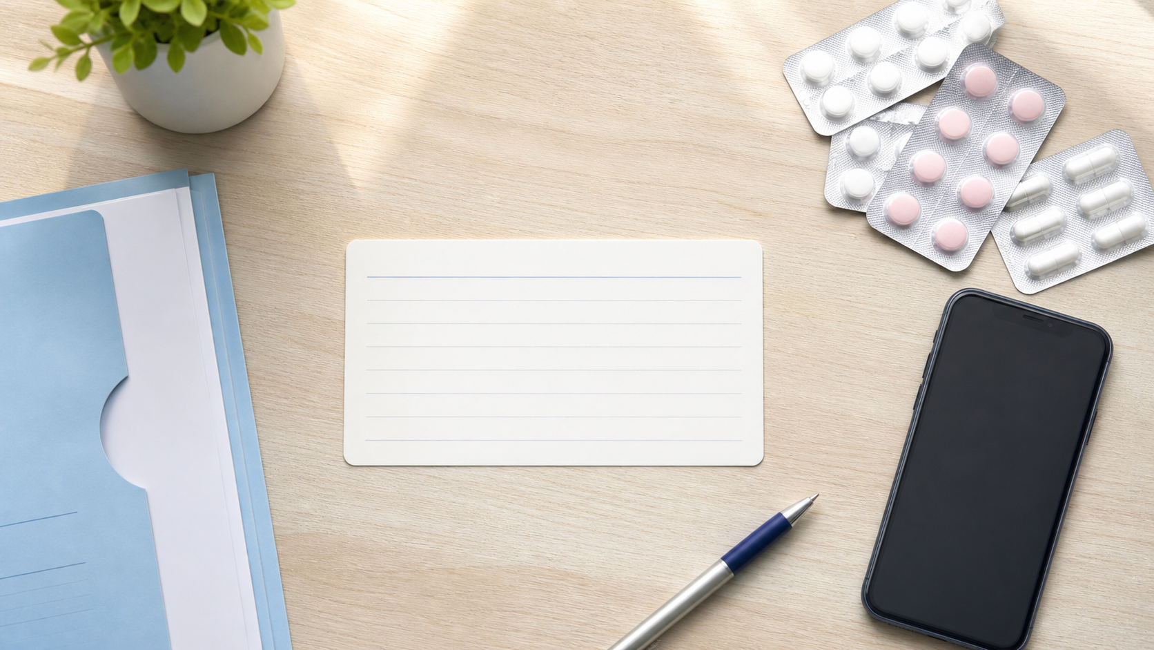 Blank medicine allergy card, medicine strips, pen, smartphone, and medical folder arranged on a clean desk